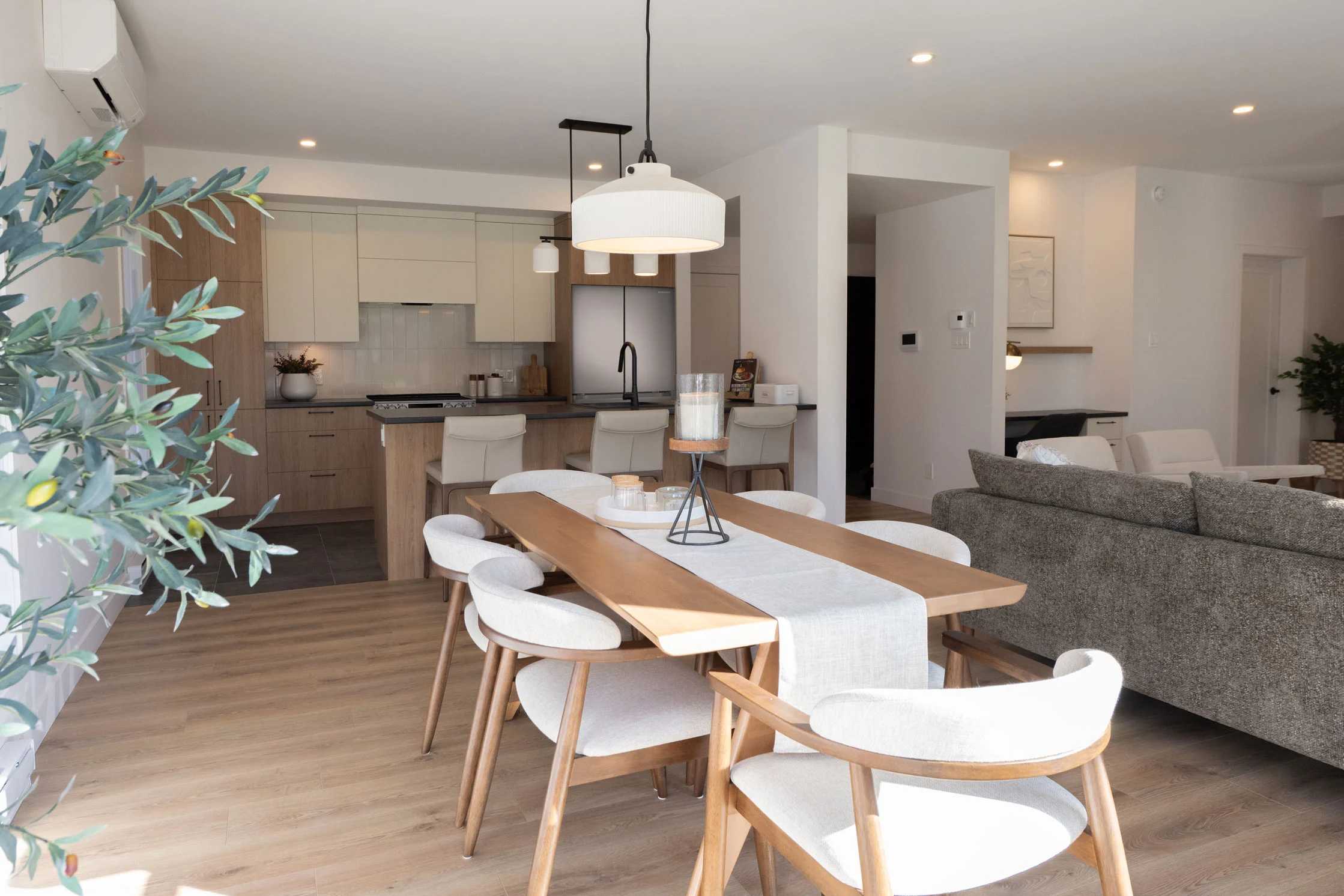 Aire ouverte salle à manger et cuisine d'un condo, styling végétal et lumière naturelle abondante.
